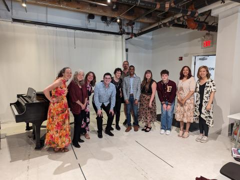 Friendly singers gather around the piano to celebrate a successful studio class